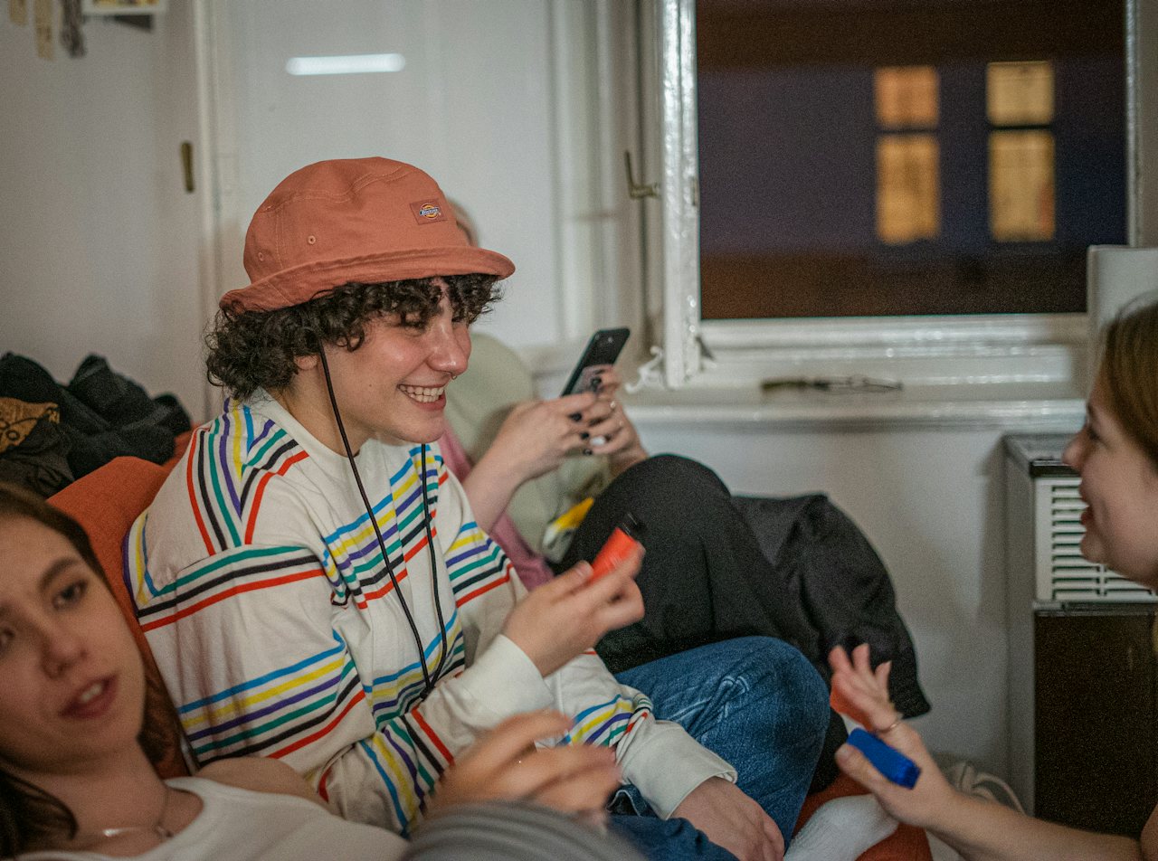 Des amis en soirée dans un appartement, l'une choisit un morceau sur son téléphone