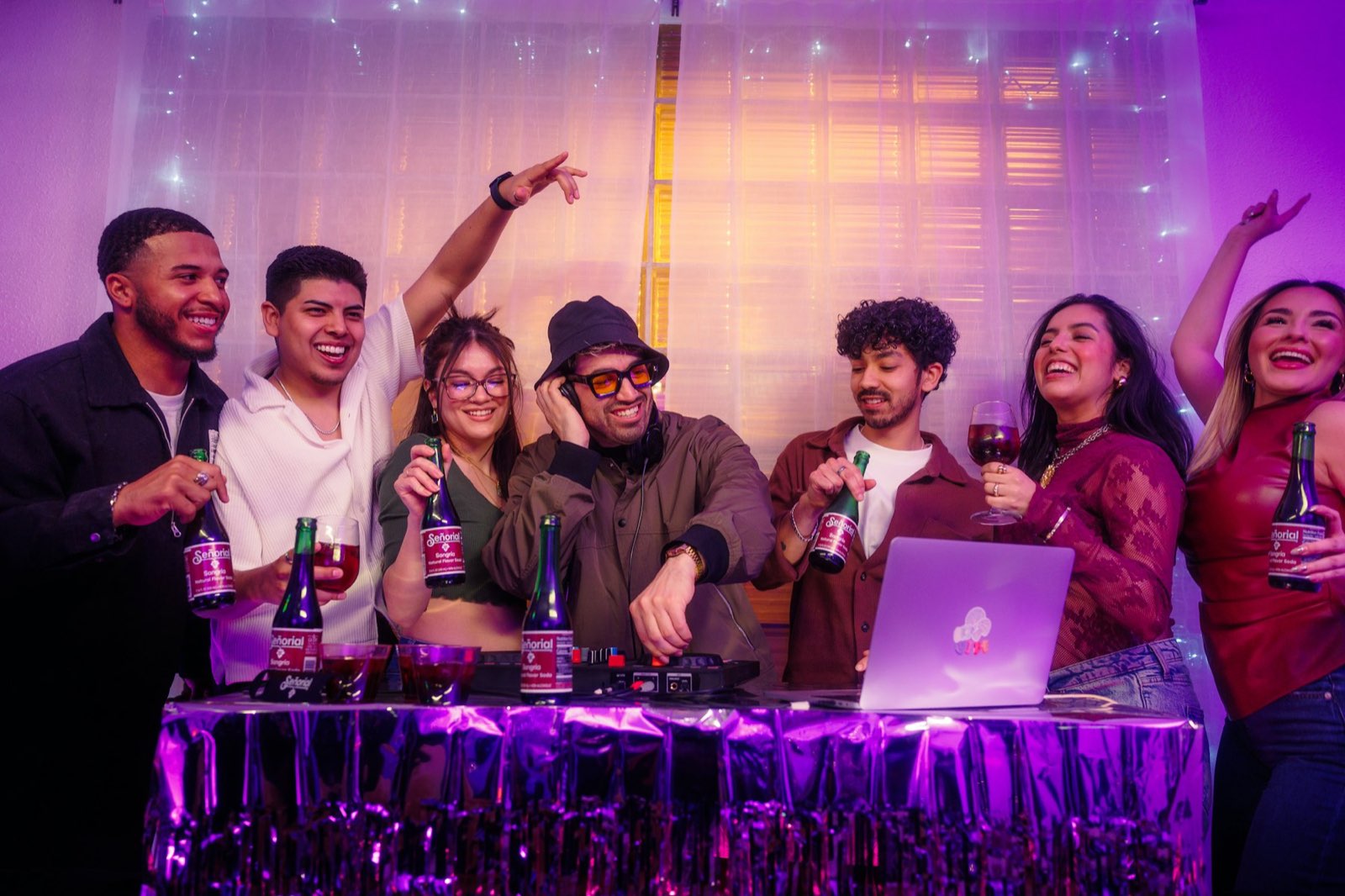 Friends partying at home around a laptop playing the music